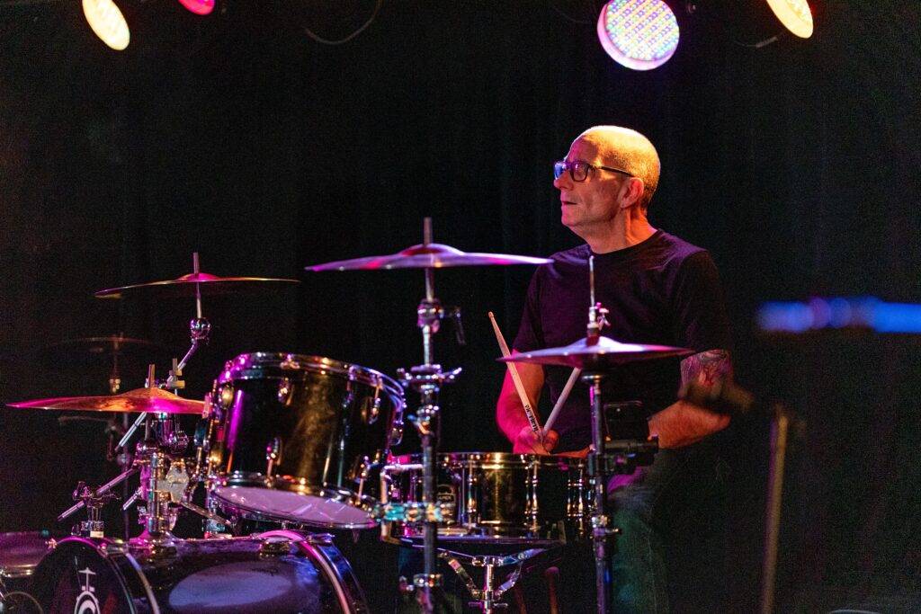 Michel playing drums on stage (2019).